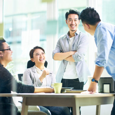 group of four happy young asian corporate people teammates meeting discussing business in office.